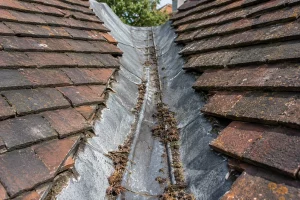 Debris build-up in a roof valley needing repair