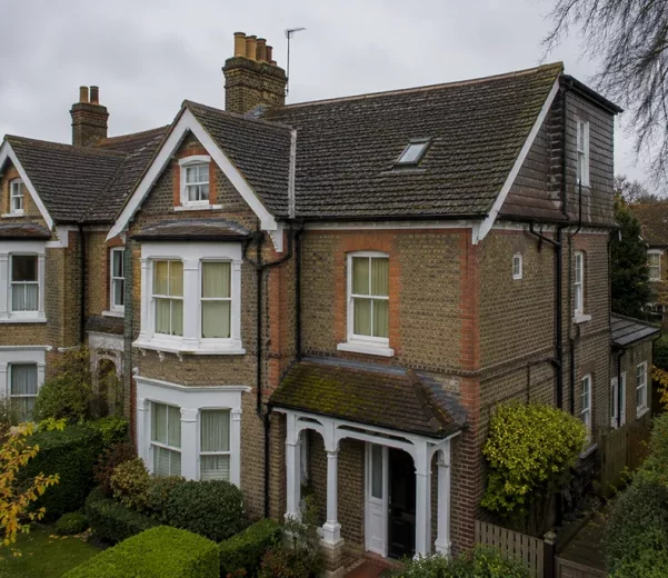 Residential house in London with pitched roof shown in late autumn context